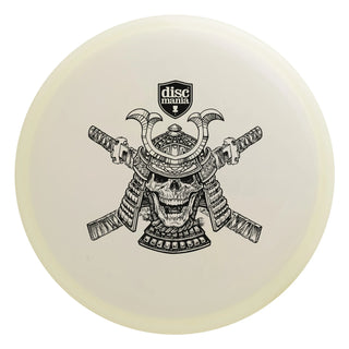 A white Discmania Active Premium Glow Sensei disc golf putter - Halloween Edition stamped with a skeleton Samurai.