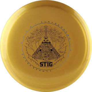 A gold colored K1 hard Stig disc golf disc with a pyramid graphic stamped. It's a Clay Edwards Tour Series edition.