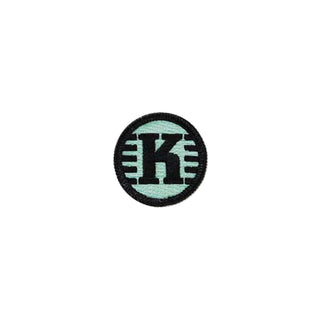 A mint-colored textile patch with the Kastaplast logo on it.